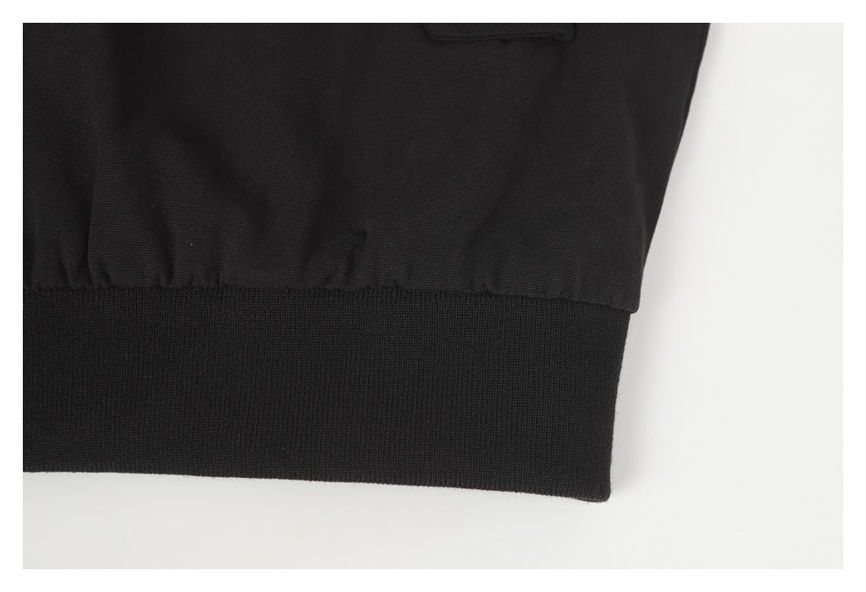 Close-up of a black garment with gathered fabric above a wide ribbed band.