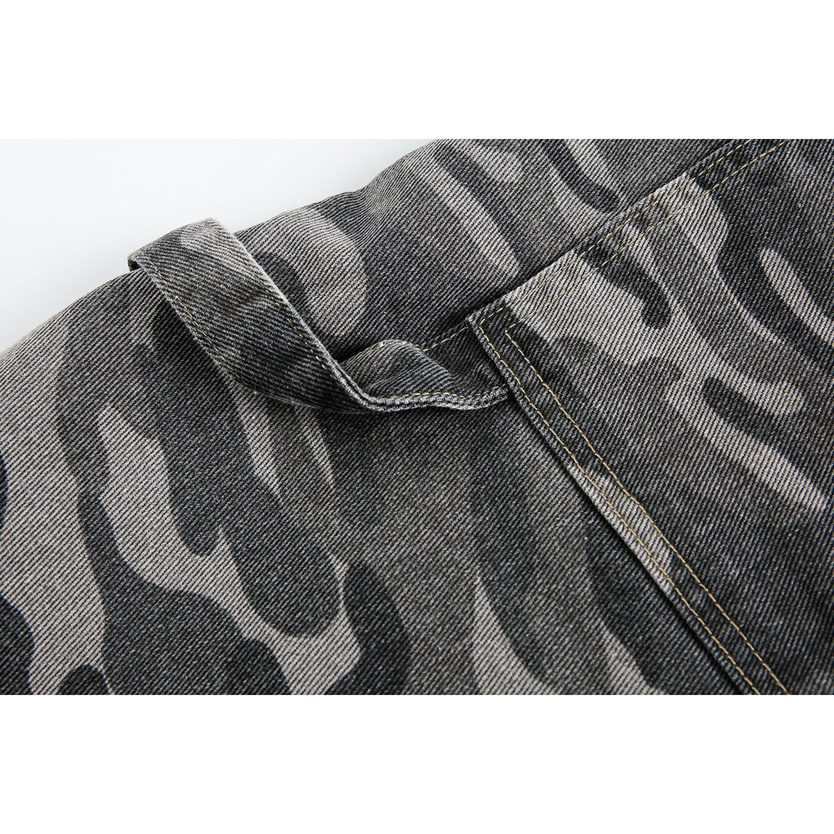 Close-up of gray camouflage shorts showing a folded edge and double-stitched seam.