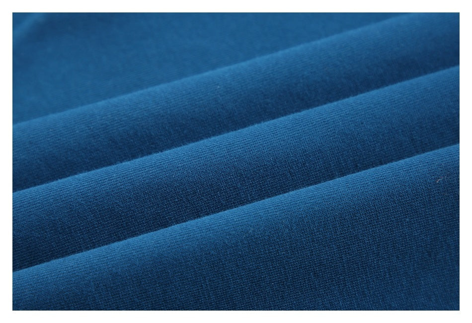 Close-up of blue garment fabric arranged in parallel folds, showing its knit texture.