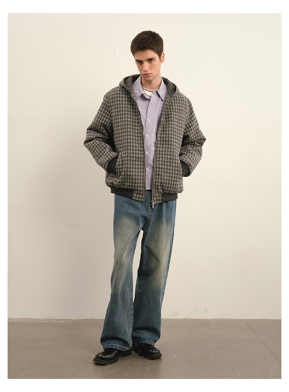 Full-length model wearing a gray checkered hooded zip jacket with dark trim and loose blue jeans.