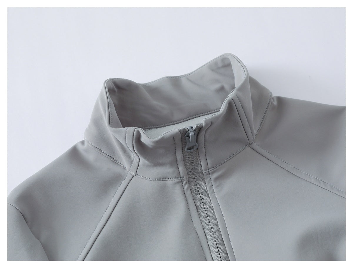 Close-up of a light gray jacket's high collar and front zipper with neat stitched seams.