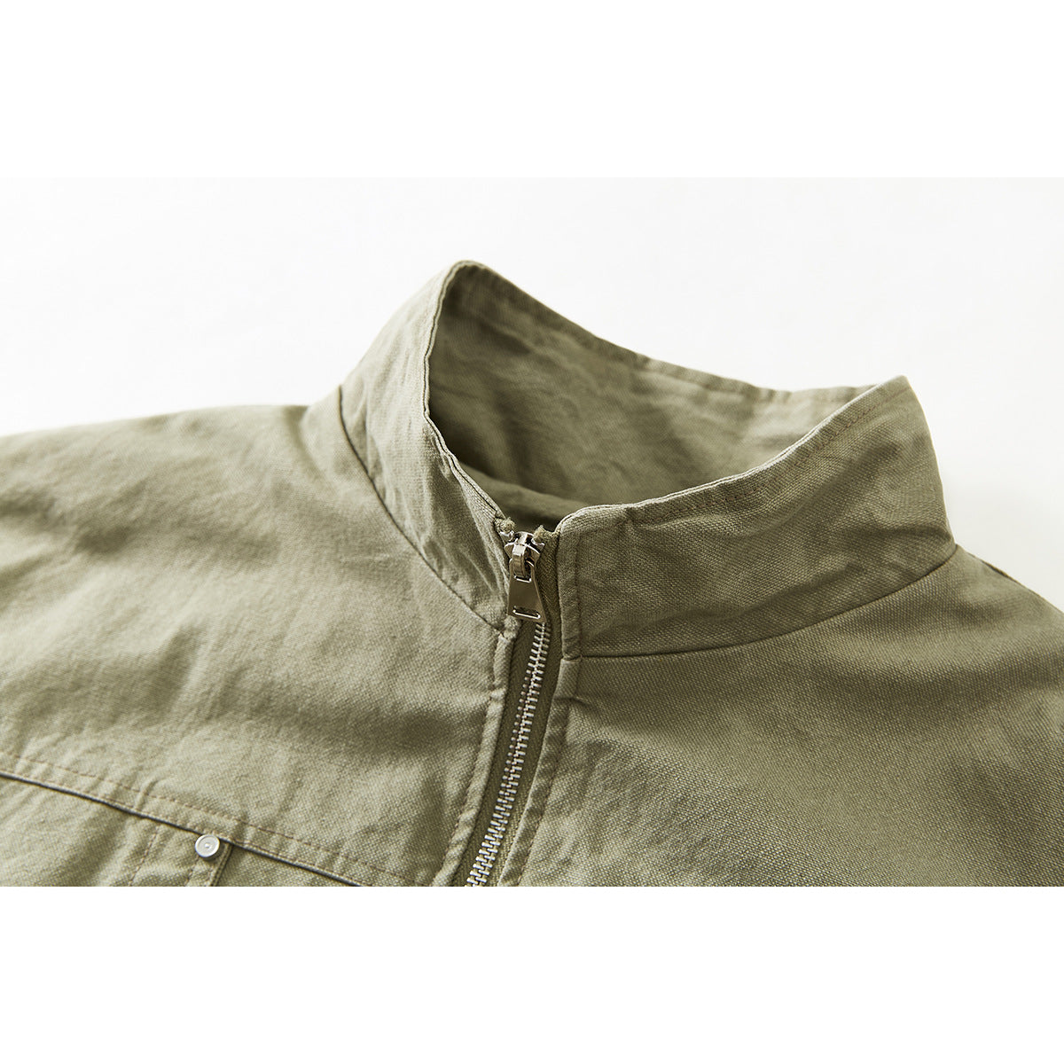 Close-up of an olive-khaki jacket's stand collar, front zipper and upper chest seam.
