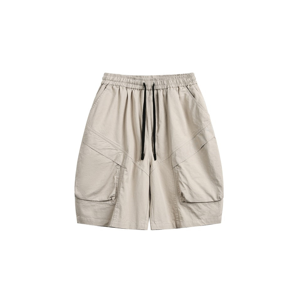 Khaki drawstring shorts with large patch pockets and diagonal seams, front view on white background