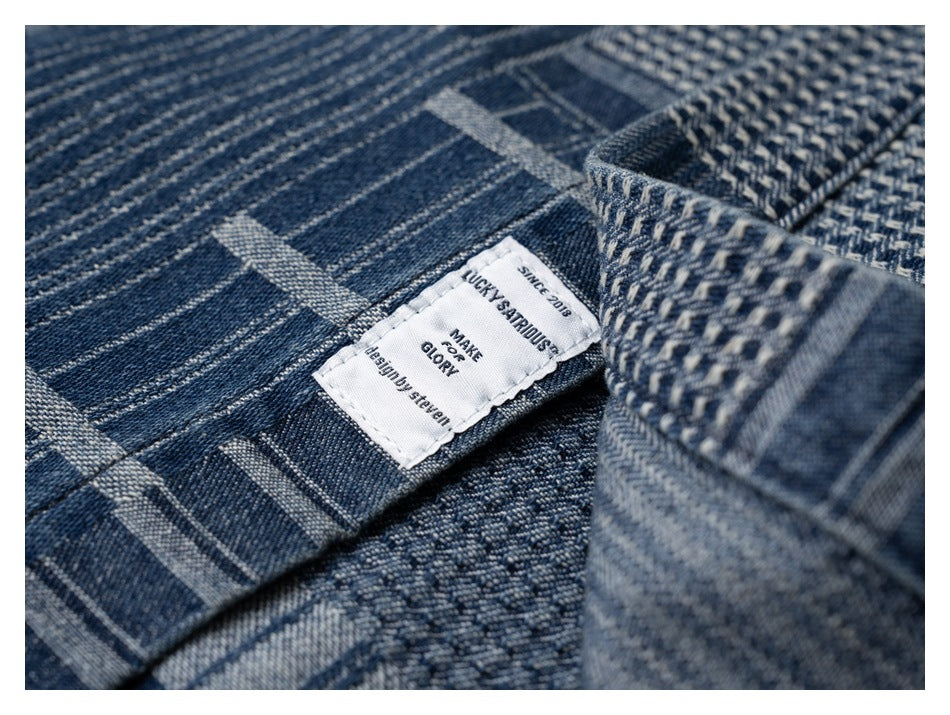 Close-up of the shirt’s dark blue patchwork fabric and a white sewn-in brand label.