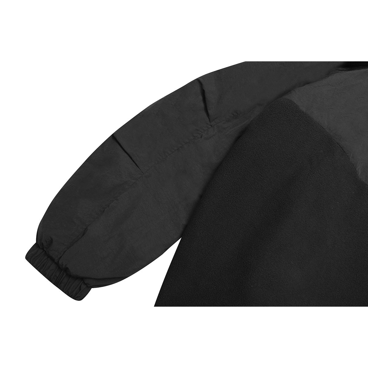 Close-up of a black garment's sleeve and body seam, showing contrasting fabric textures.