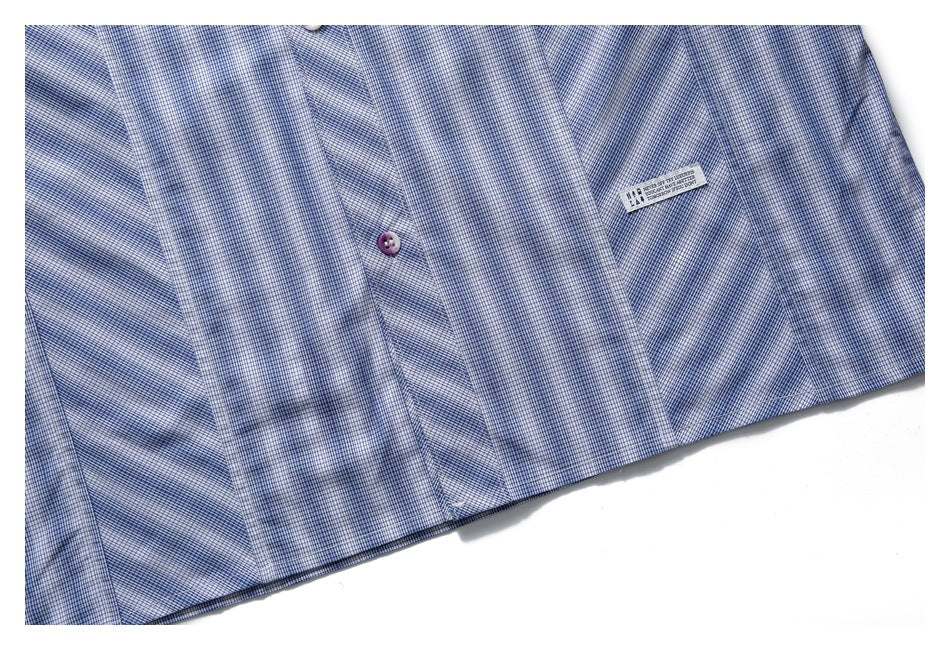 Cropped flat view of a blue-and-white checked shirt front, showing buttons and a chest pocket with a small sewn label.