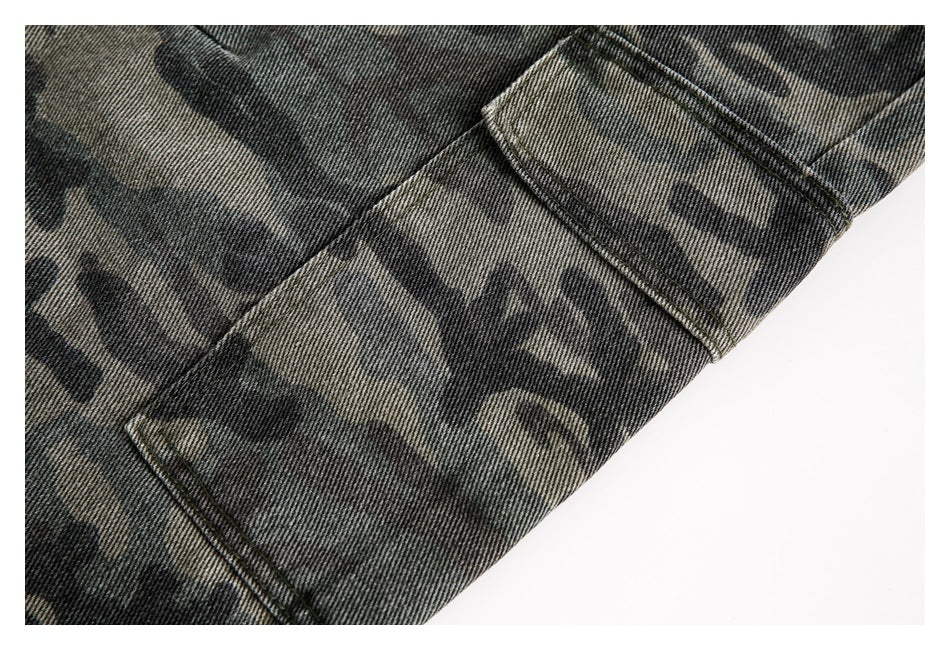 Close-up of a rectangular cargo pocket and stitching on dark camouflage trousers.