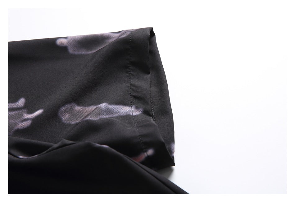 Close-up of the black shirt's short sleeve and stitched cuff, with a blurred figure print.
