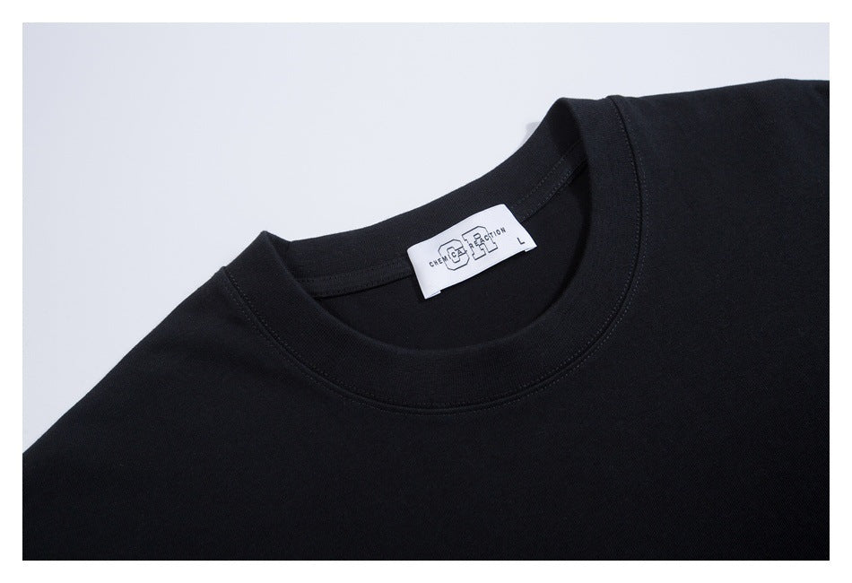 Close-up of a black T-shirt's crew neckline and white neck label with small lettering.