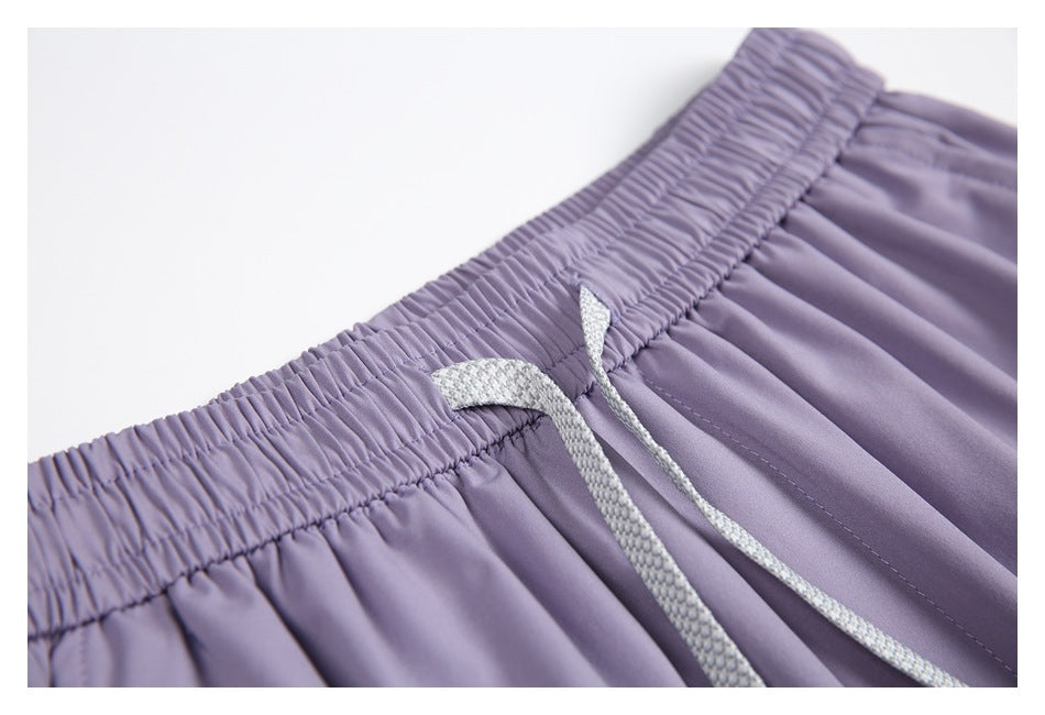 Close-up of lavender trousers showing the gathered elastic waistband and light gray drawstring.