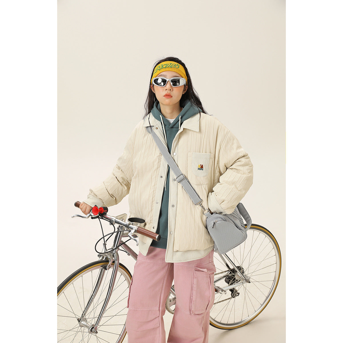 Front view of a model wearing a cream quilted snap-front jacket with a chest pocket and ribbed cuffs.
