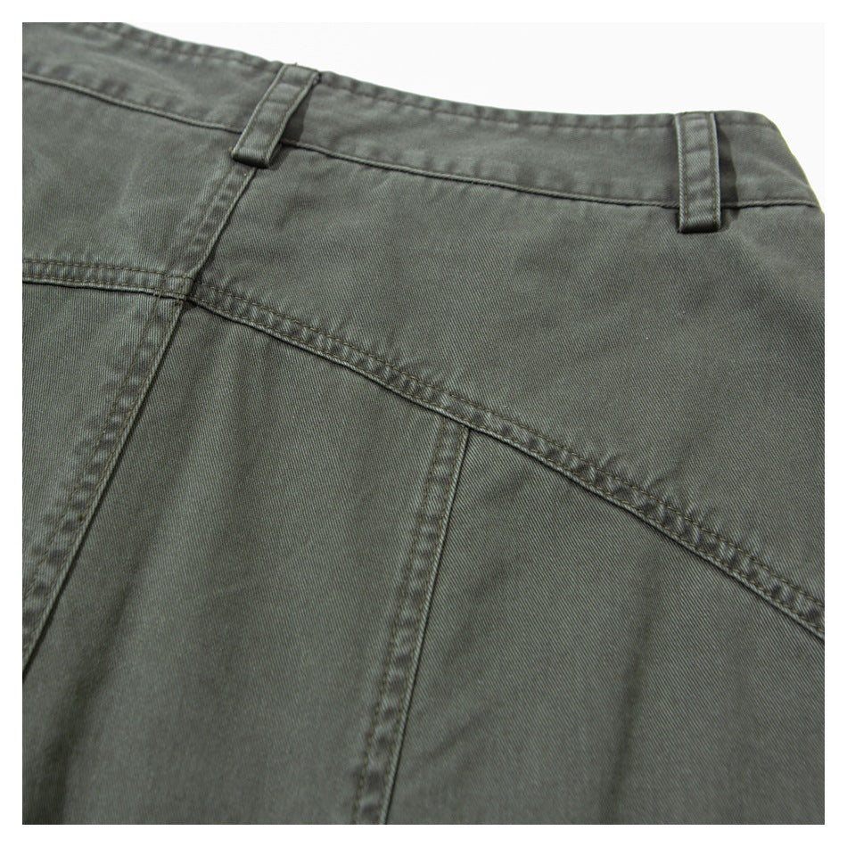 Close-up of olive-gray trousers showing the waistband, belt loops, and diagonal seam.