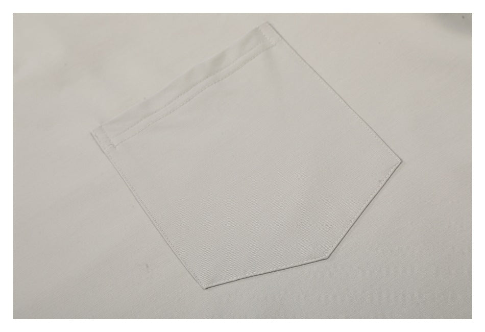 Close-up of a plain light gray T-shirt's stitched chest pocket.