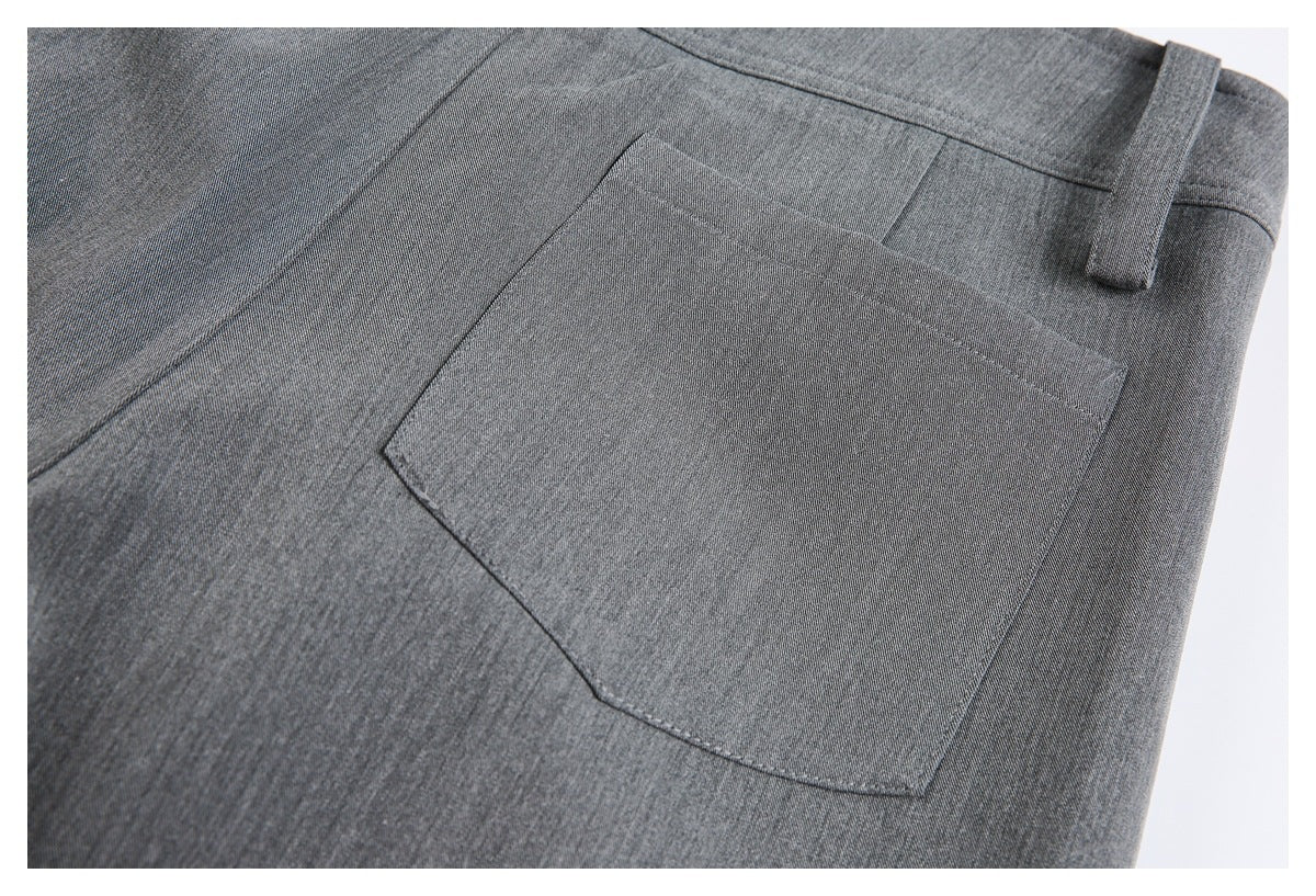 Close-up of charcoal-gray trousers showing a rectangular back pocket and belt loop.