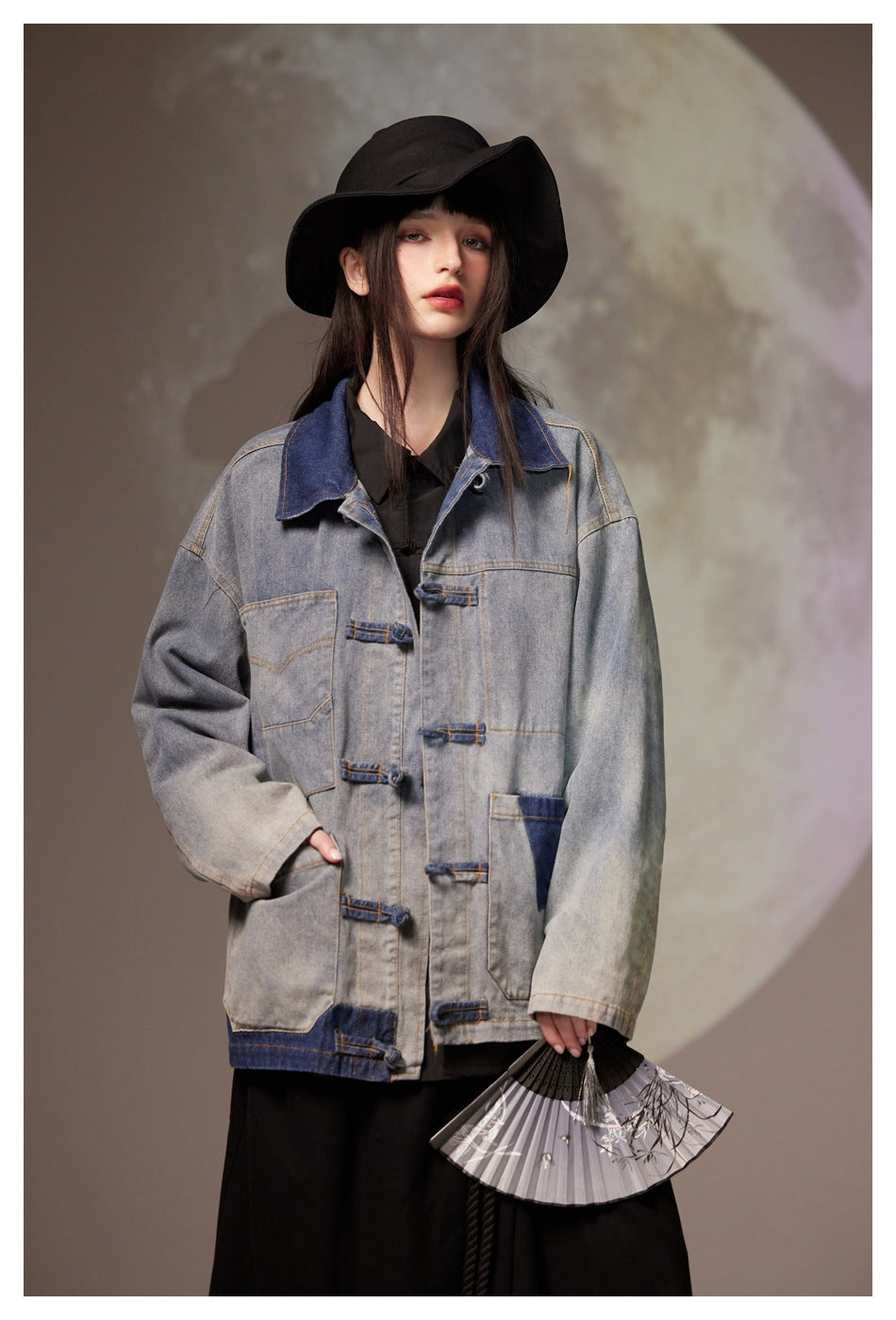 Model wearing an oversized gray washed denim jacket with a dark blue collar, contrast patches and loop closures.