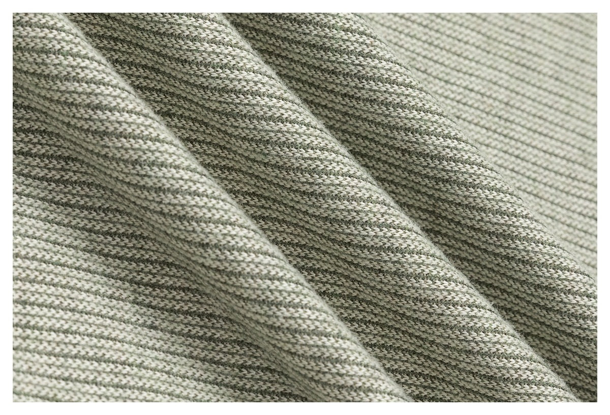 Close-up of draped gray and off-white knit fabric showing its textured weave.