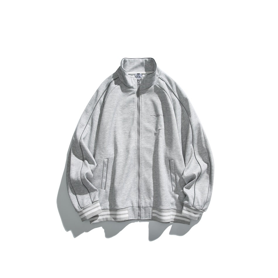 Light gray zip-front stand-collar jacket with raglan sleeves, piping and white-striped ribbed cuffs and hem, flat lay