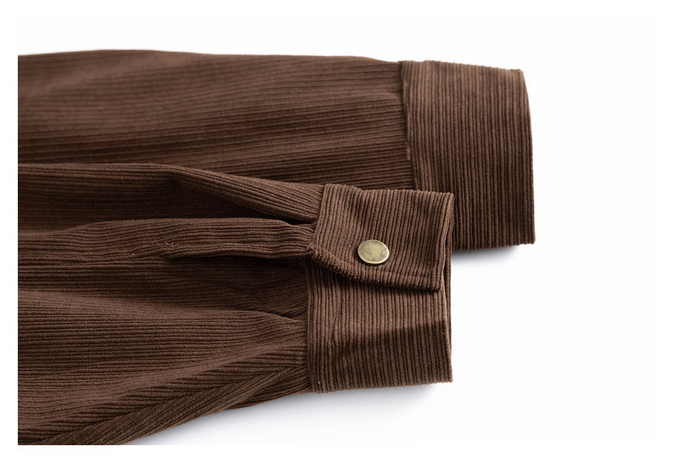 Close-up of a brown corduroy sleeve cuff with a brass snap closure.