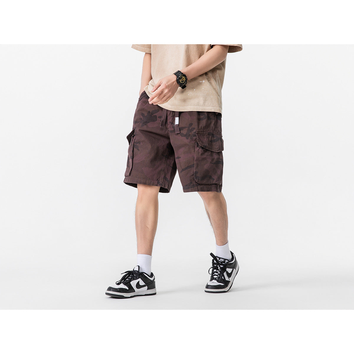 Model wearing dark burgundy camouflage cargo shorts with a drawstring waist and flap pockets.