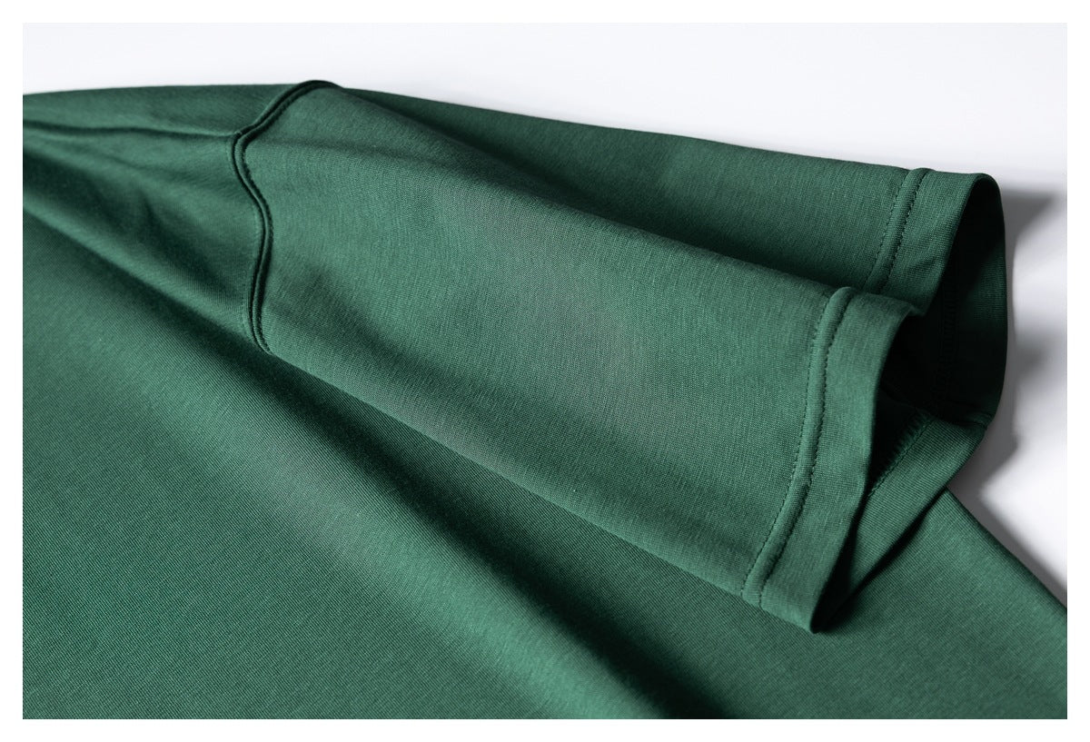 Close-up of the dark green T-shirt's short sleeve and stitched cuff.