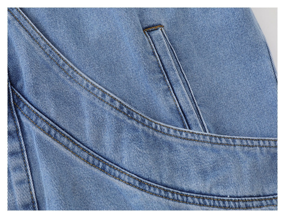 Close-up of a curved denim pocket panel, inset opening, and contrast stitching.