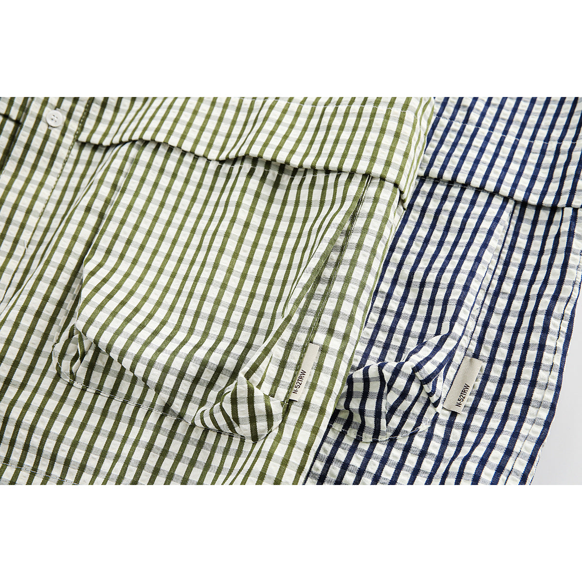 Close-up of olive and navy striped shirts showing their button plackets, seams and pocket details.