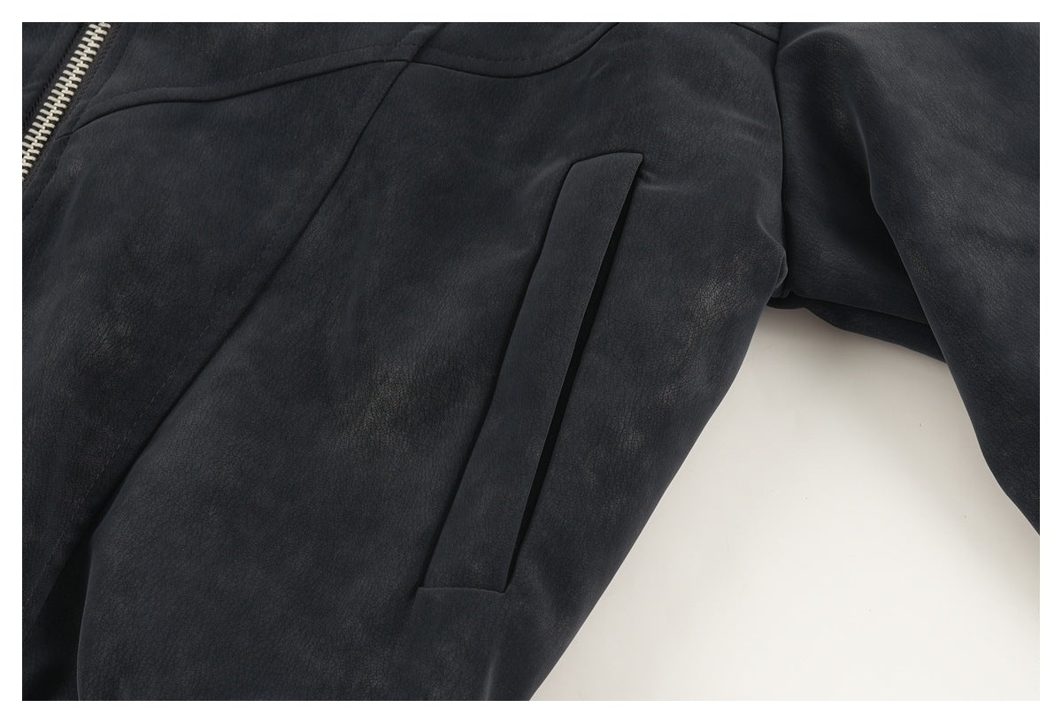 Close-up of a dark jacket's angled welt pocket and textured panel seams.