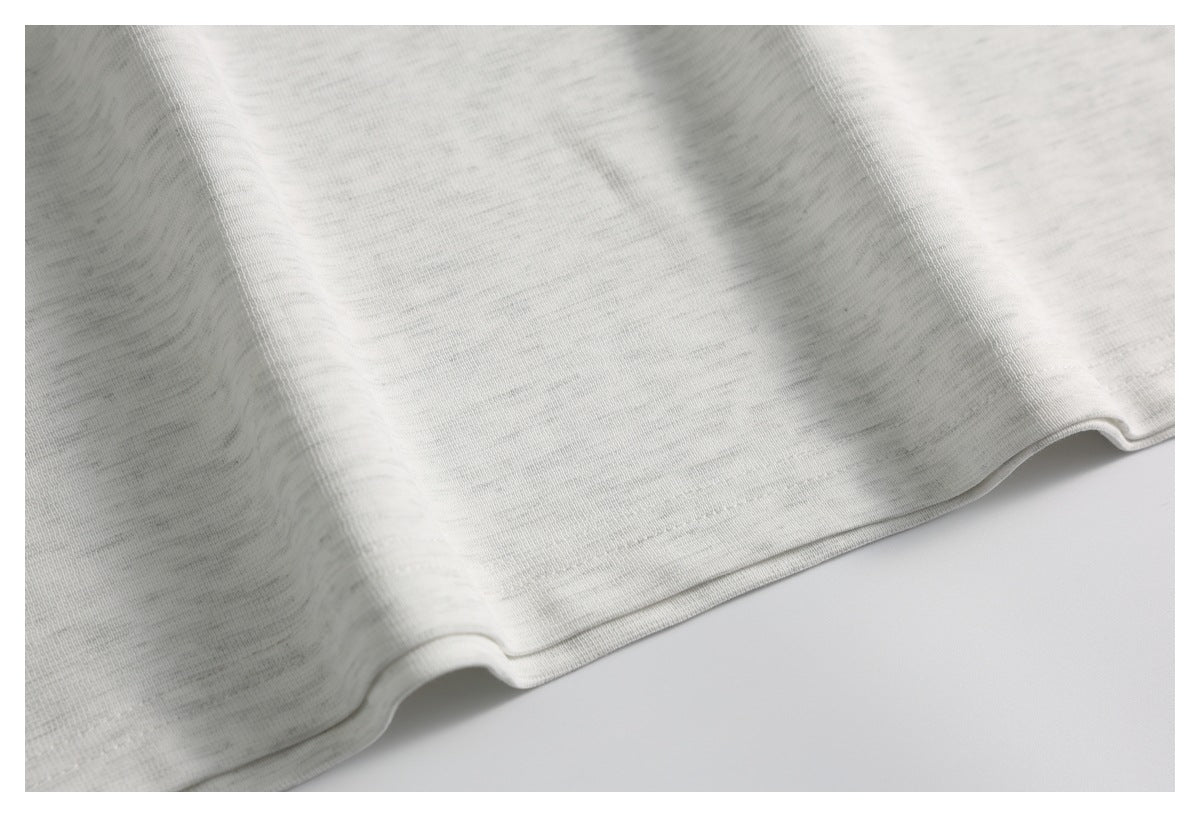 Close-up of the light gray fabric and its stitched hem.