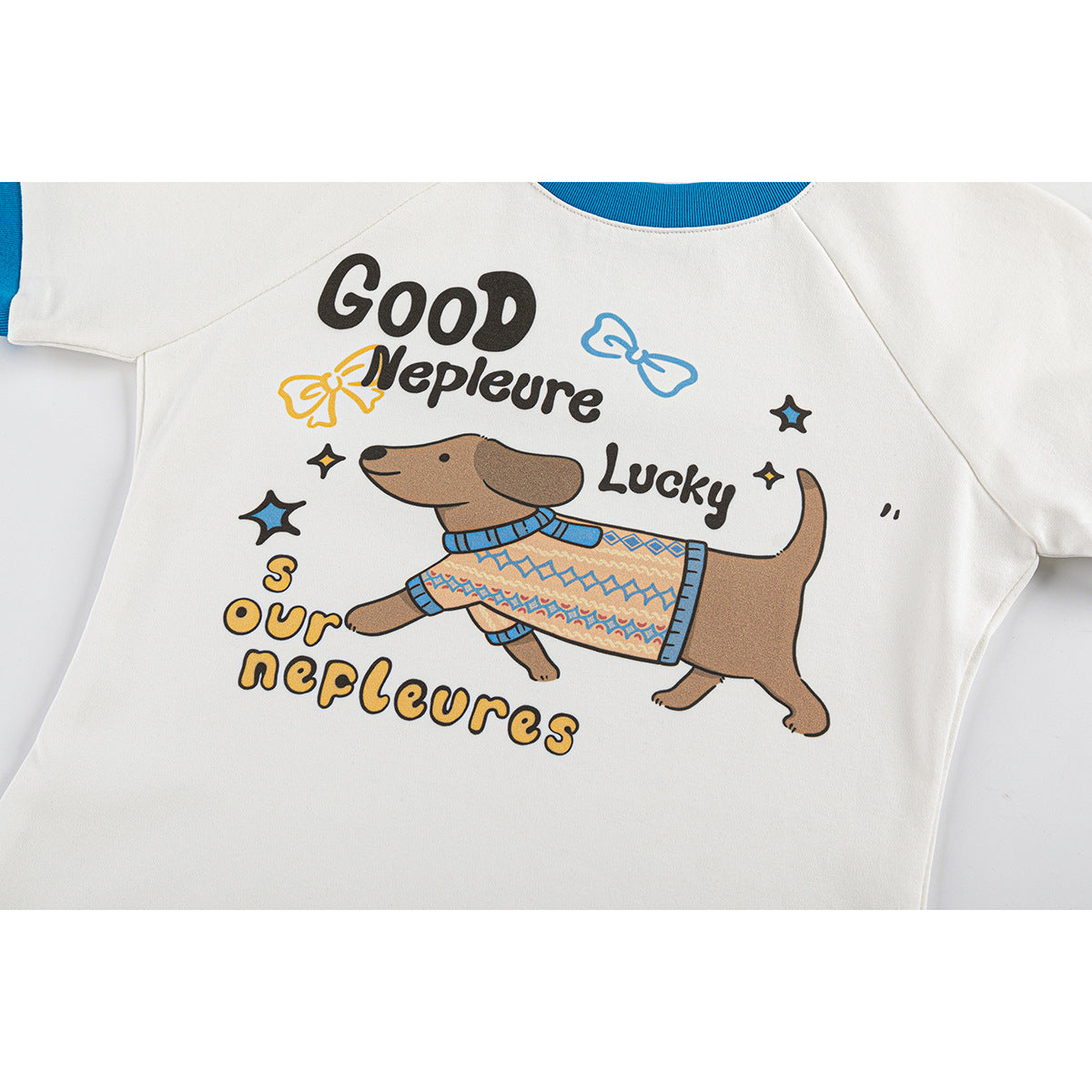 Close view of a white short-sleeve shirt with blue trim and a colorful cartoon dog graphic with English lettering.