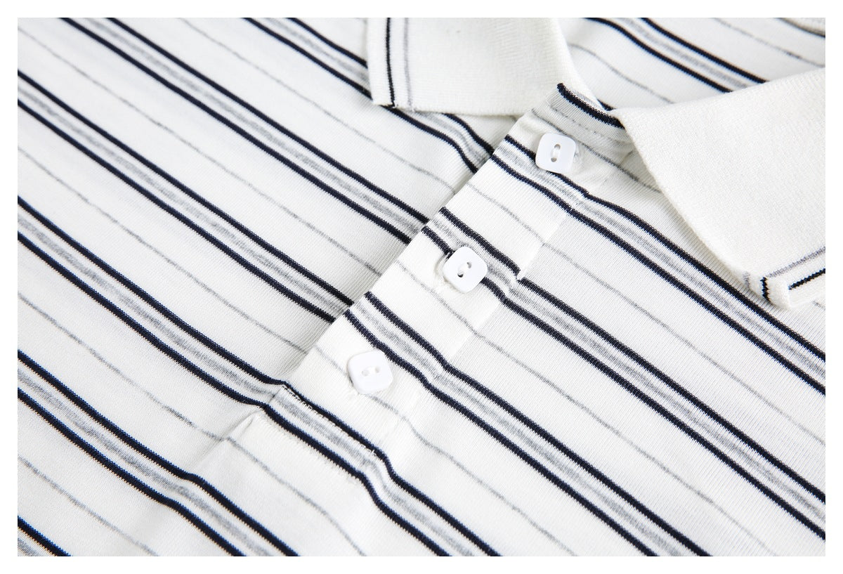Close-up of the collar and three-button placket on a white polo shirt with narrow black and gray stripes.