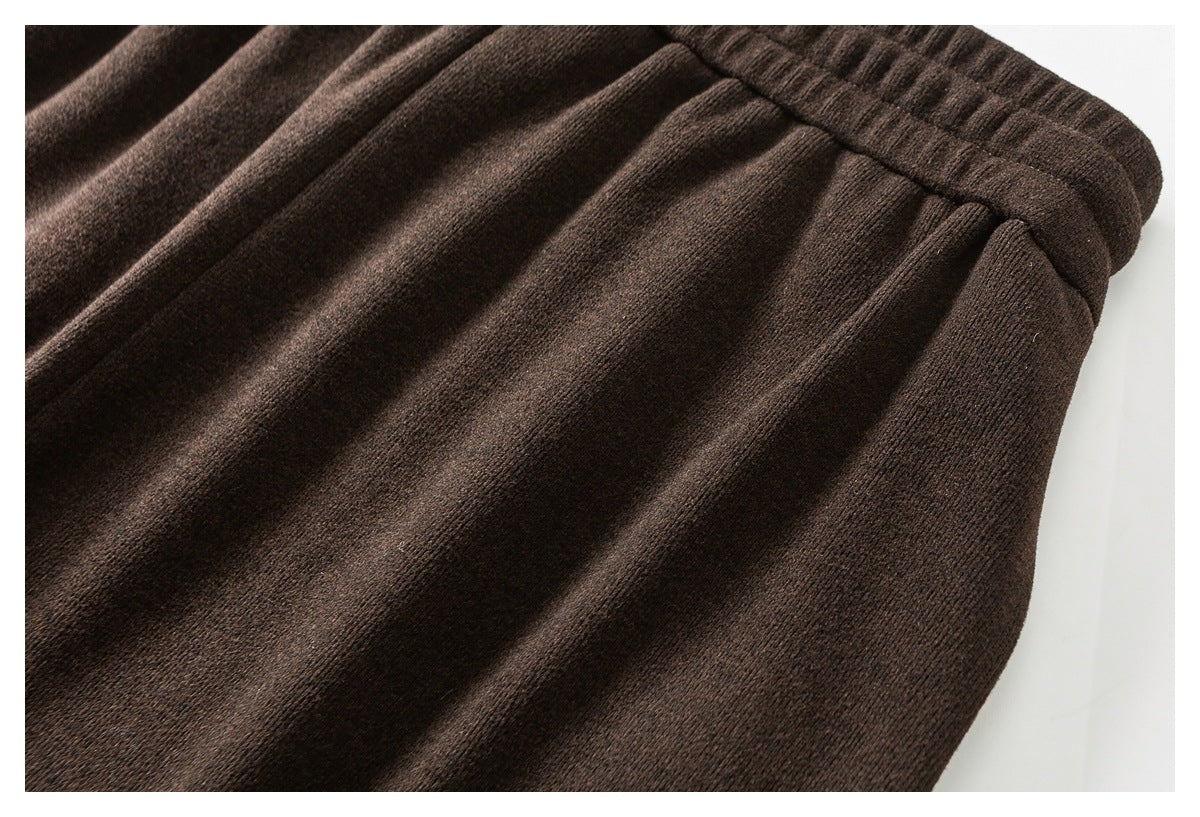 Close-up of dark brown pants showing the waistband and softly gathered fabric below it.