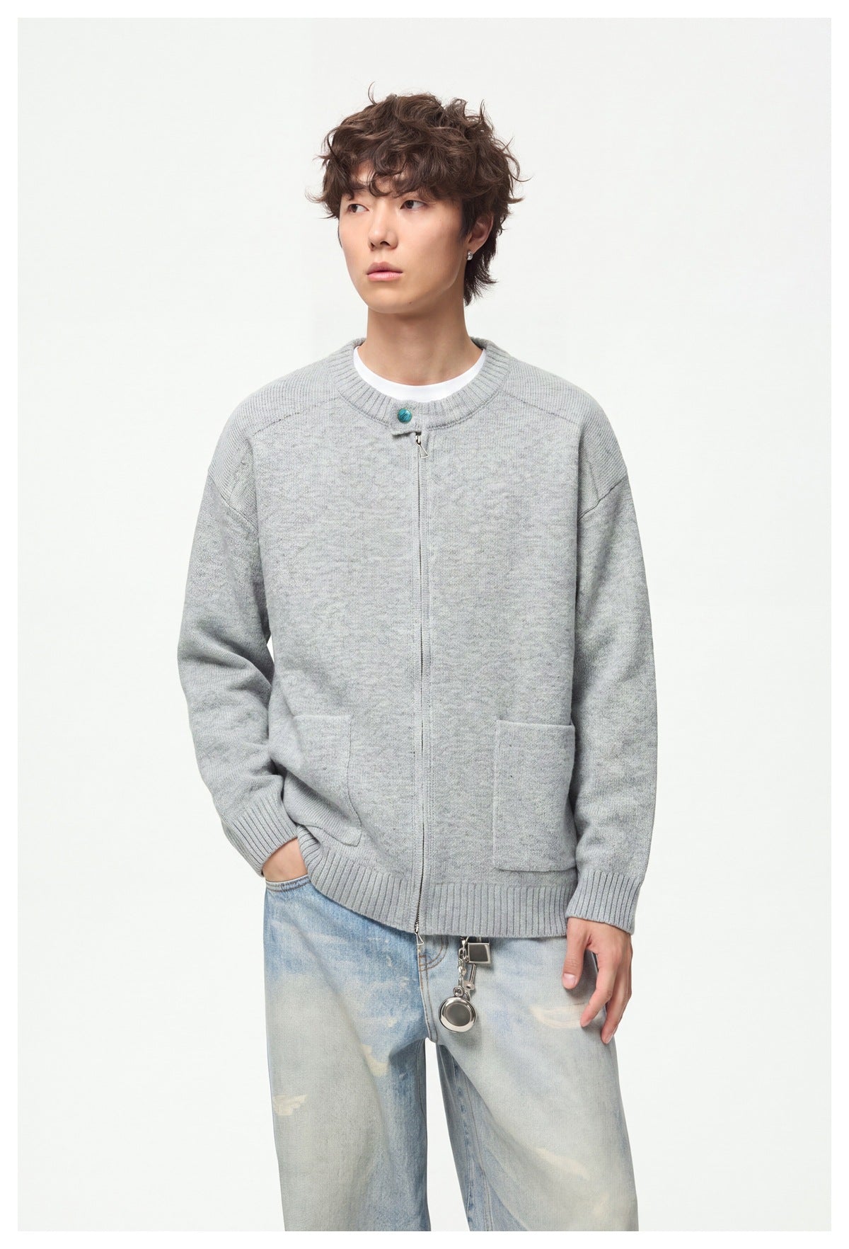 Model wearing a light gray zip-front cardigan with ribbed trim and patch pockets, shown from the front.