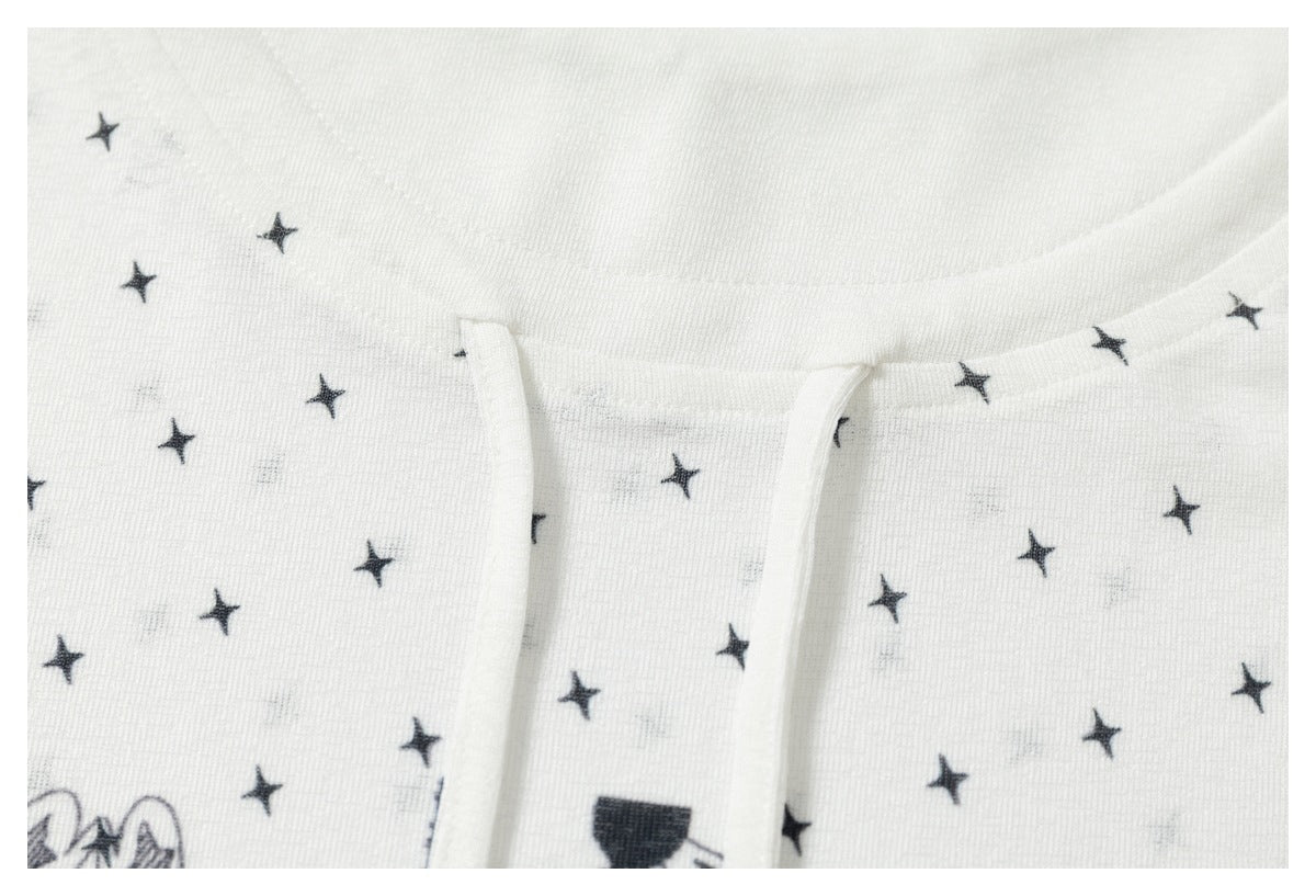 Close-up of the neckline and front opening on a white top with scattered black stars.