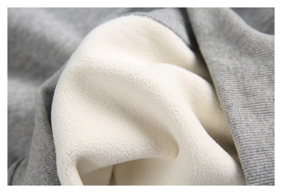 Close-up showing the cream-colored plush interior lining against heather-gray sweatshirt fabric.