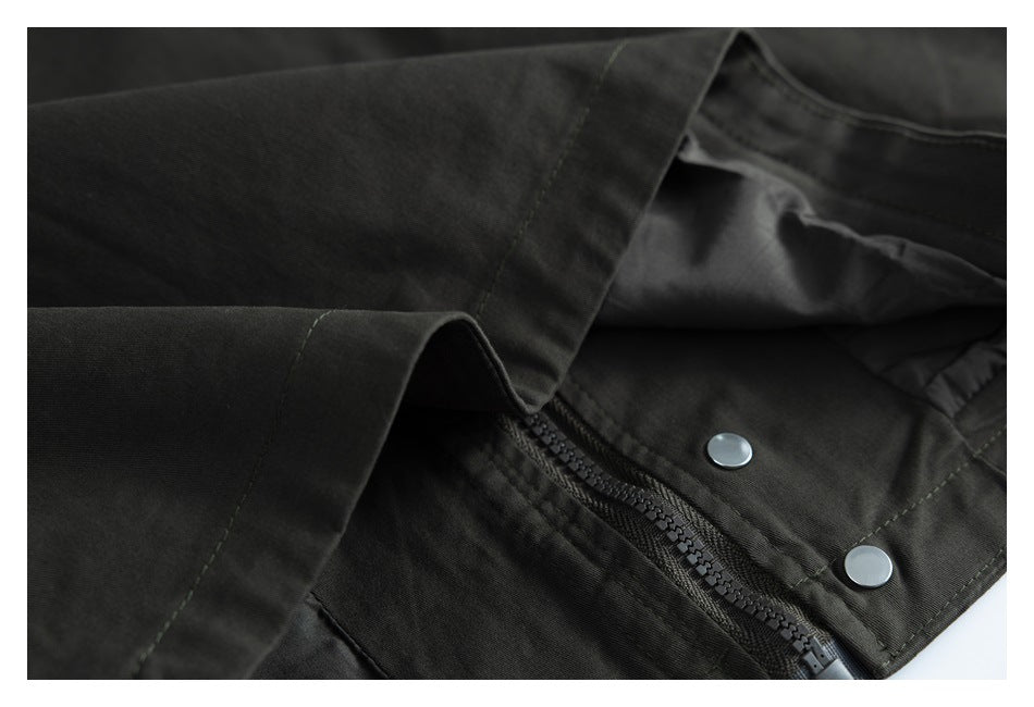 Close-up showing a dark garment's zipper, silver snaps, and overlapping front placket.