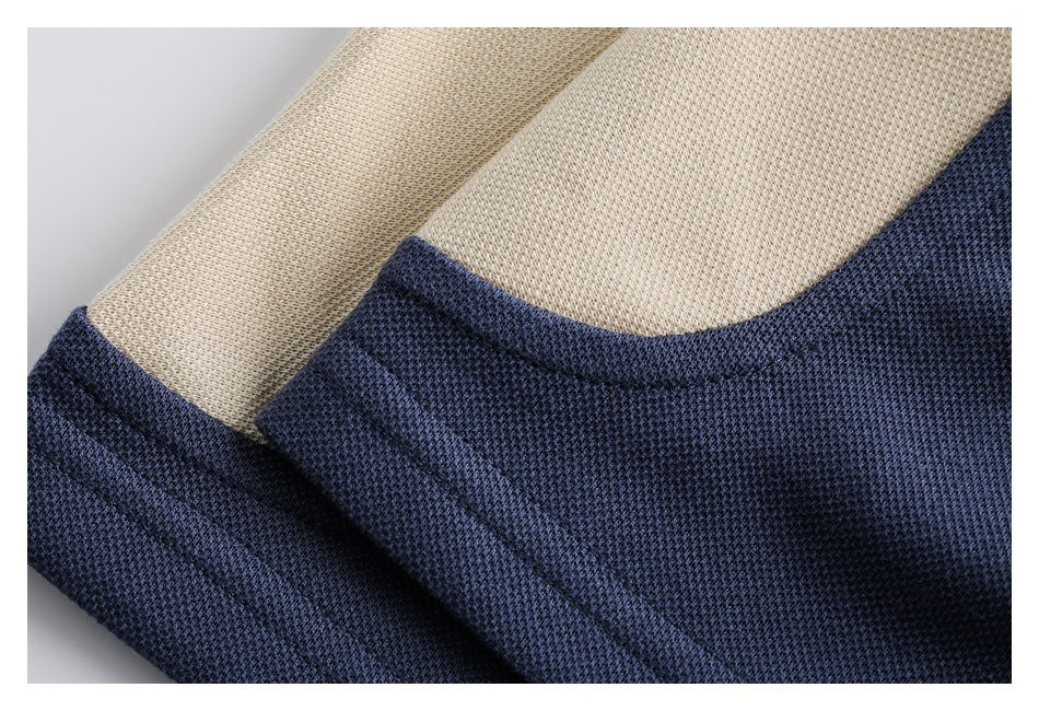 Close-up of the navy polo neckline and cream textured fabric.
