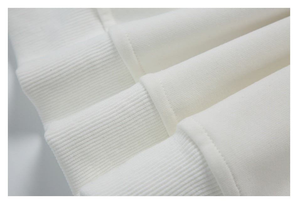 Close-up of ribbed white cuffs and stitched seams on the garment.