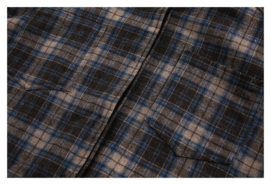 Close-up of the jacket's brown and blue plaid front, showing a button placket and patch pocket.