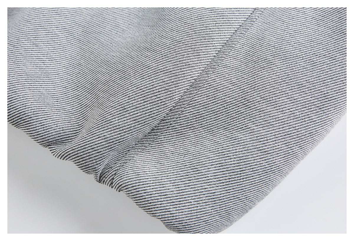Close-up of a stitched seam across black-and-white striped garment fabric.