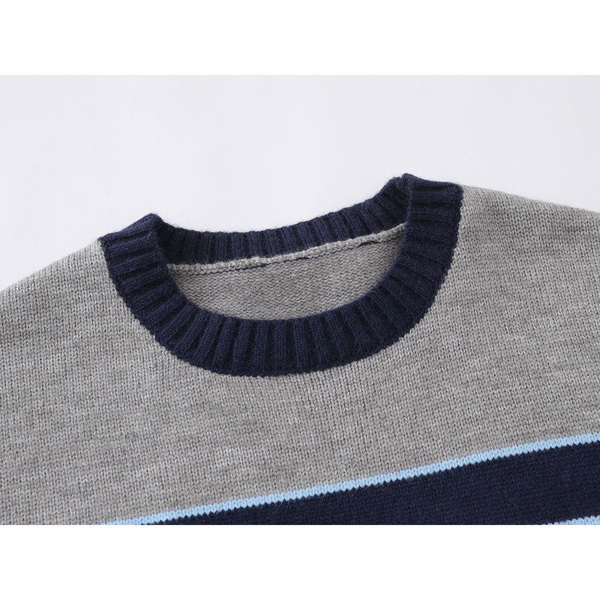 Close-up of a gray knit sweater with a navy ribbed crew neck and a light blue and navy stripe.