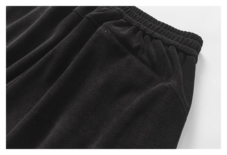 Close-up of a black jogger pocket beneath the gathered elastic waistband.