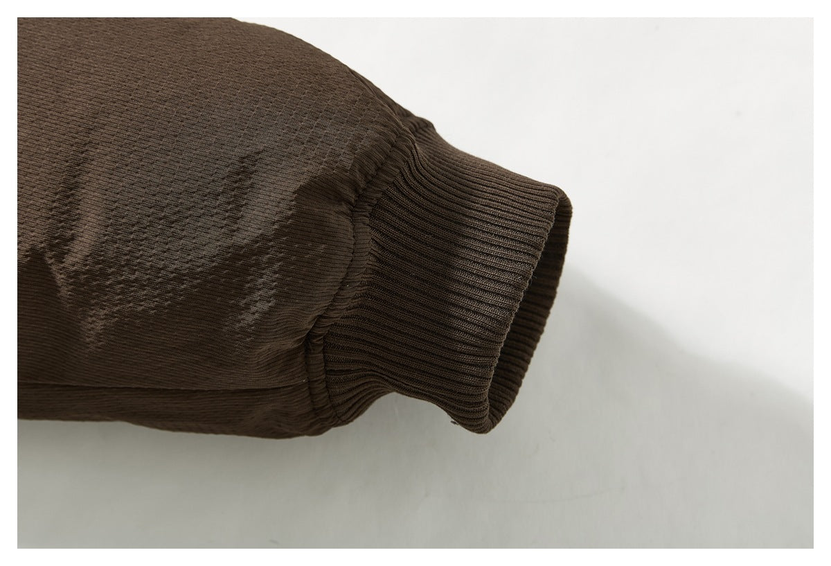 Close-up of a dark brown jacket sleeve ending in a wide ribbed cuff.