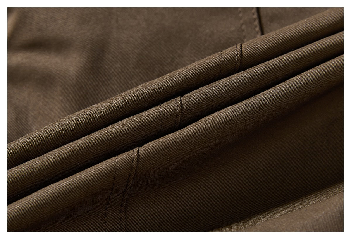 Close-up of dark brown fabric folds showing diagonal weave texture and stitched seams.