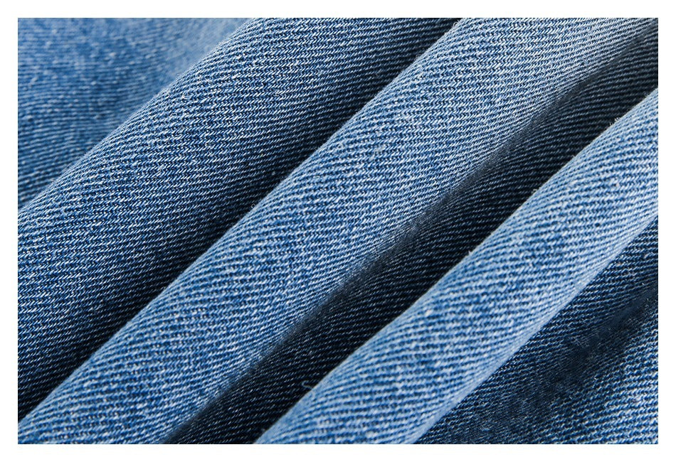 Extreme close-up of blue denim fabric showing its diagonal weave and varied wash.