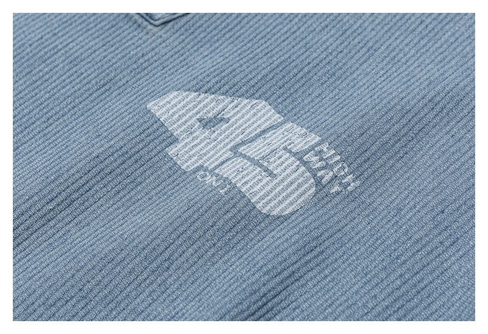 Close-up of a white graphic printed on light blue textured jacket fabric.