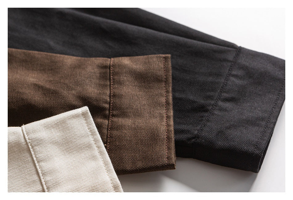 Close-up of cream, brown, and black shirt cuffs showing folded hems and stitching.