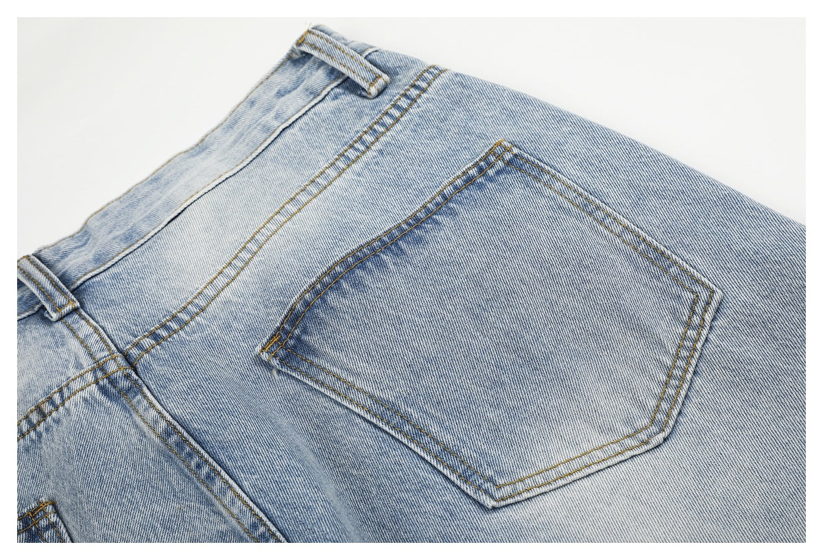 Close-up of a light-wash denim jeans back pocket with golden stitching and belt loops.