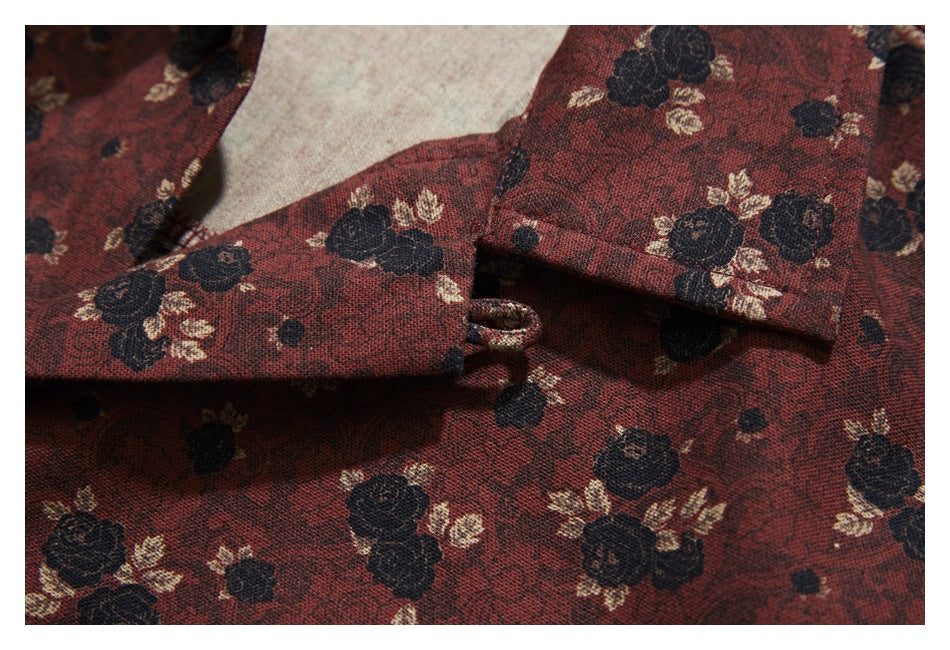 Close-up of the burgundy floral shirt's front placket, buttonhole, and fabric pattern.
