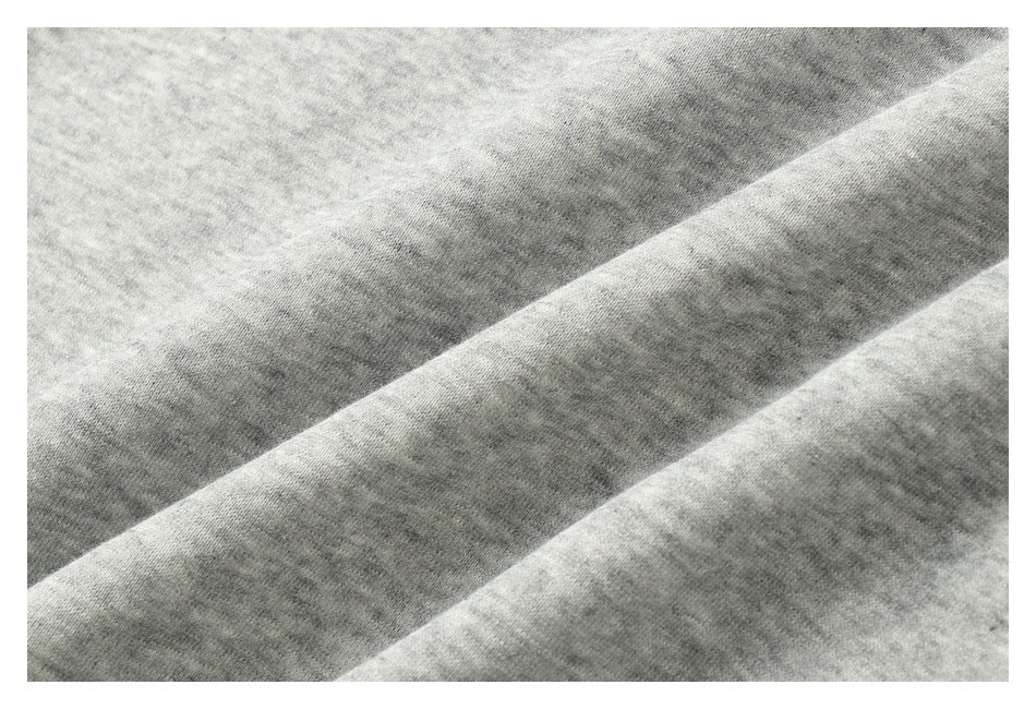 Close-up of the heathered texture of light gray fabric, with a folded edge.