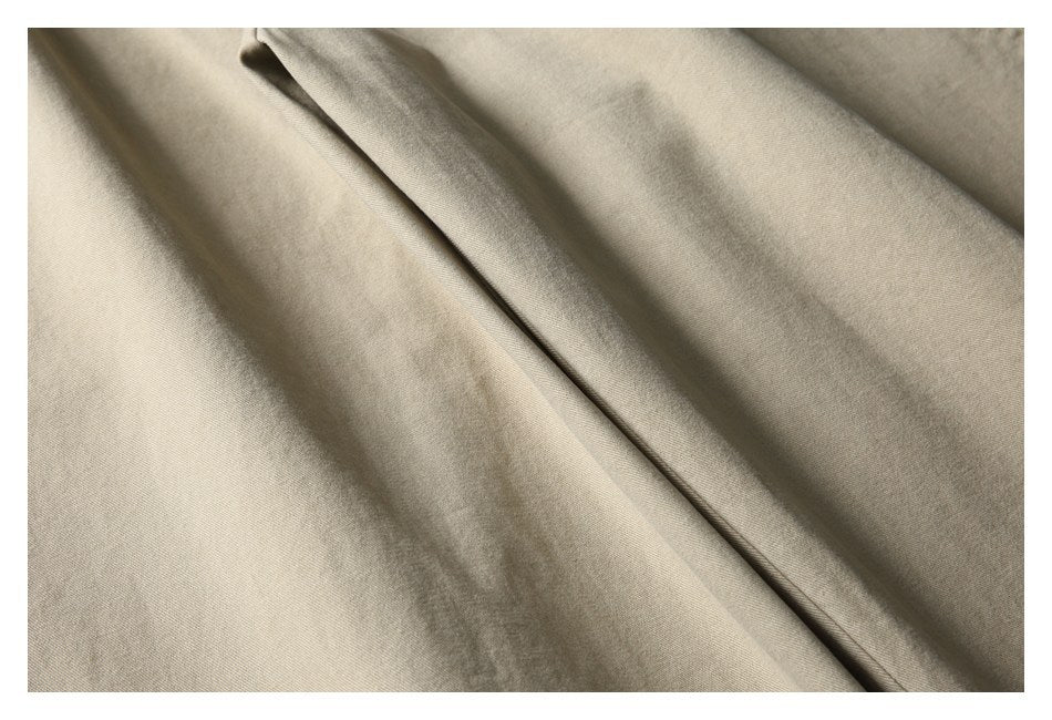 Close-up of smooth beige fabric with soft folds.